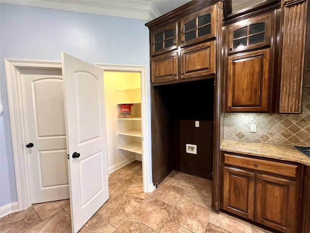 kitchen featuring crown molding, light stone counters, decorative backsplash, and dark brown cabinetry