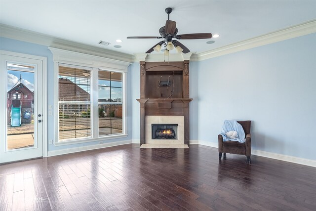 unfurnished room featuring dark hardwood / wood-style flooring, crown molding, a fireplace, and ceiling fan