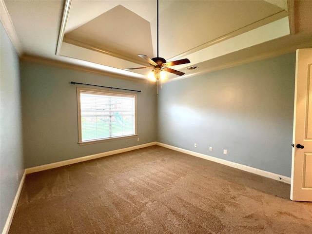 carpeted spare room with crown molding, a raised ceiling, and ceiling fan