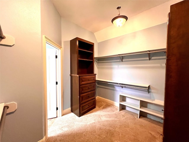 spacious closet with light colored carpet and lofted ceiling