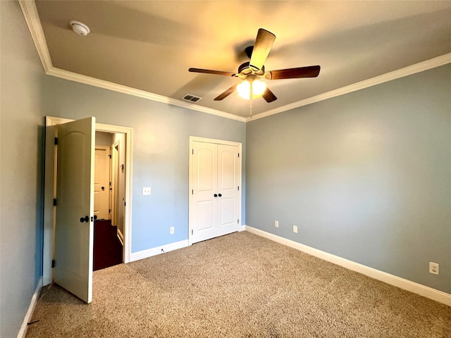 unfurnished bedroom with crown molding, a closet, ceiling fan, and carpet flooring