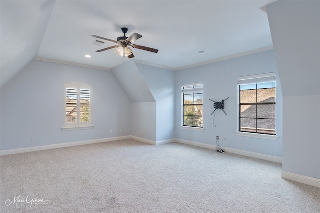 additional living space with lofted ceiling, a healthy amount of sunlight, light carpet, and ceiling fan