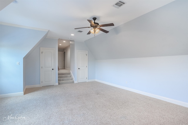 additional living space with vaulted ceiling, light carpet, and ceiling fan