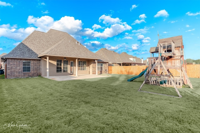 back of property featuring a playground, a patio, and a lawn