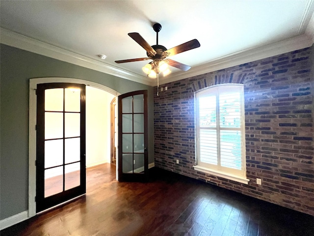 spare room with dark hardwood / wood-style flooring, crown molding, french doors, and brick wall