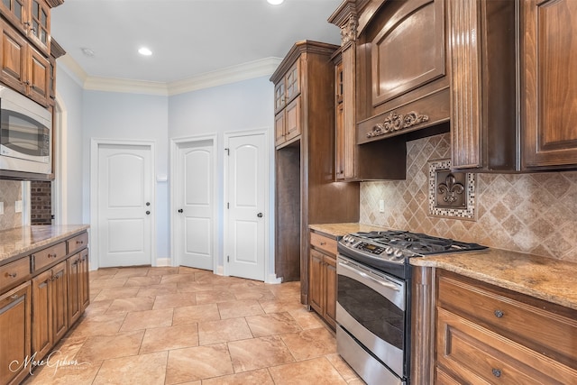 kitchen featuring light stone counters, appliances with stainless steel finishes, crown molding, and decorative backsplash