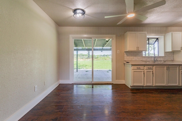 kitchen with white cabinetry, sink, backsplash, dark hardwood / wood-style floors, and ceiling fan