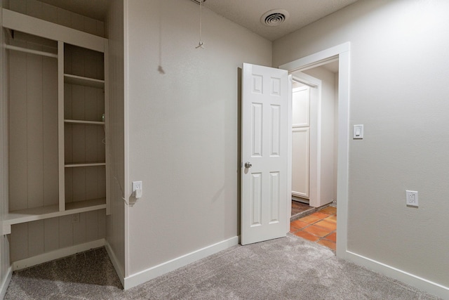 unfurnished bedroom with light colored carpet and a closet