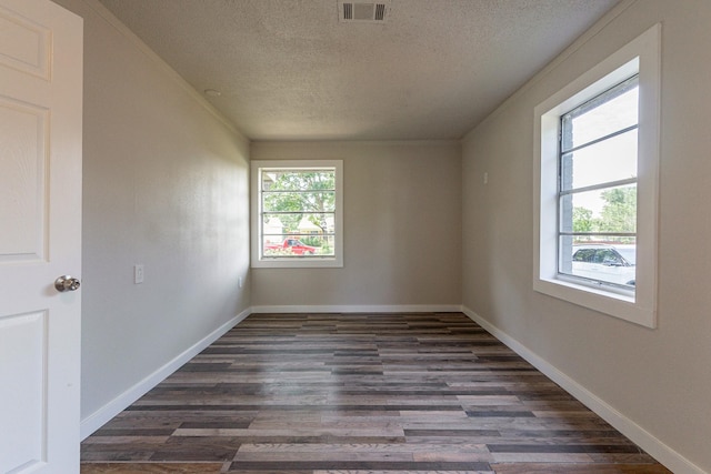 spare room featuring a textured ceiling and dark hardwood / wood-style flooring