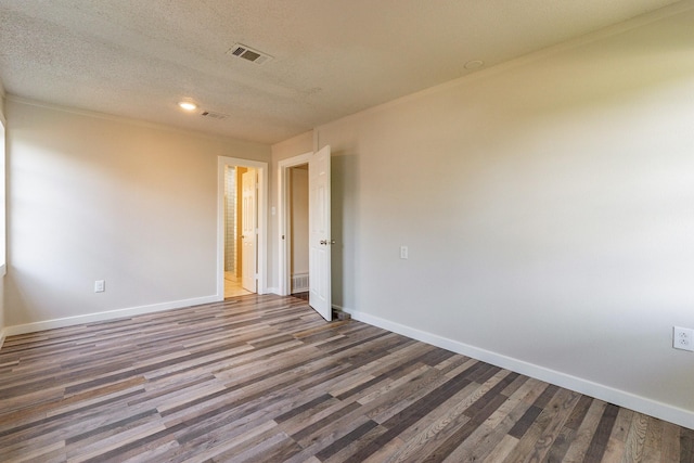 unfurnished room with wood-type flooring, a textured ceiling, and crown molding