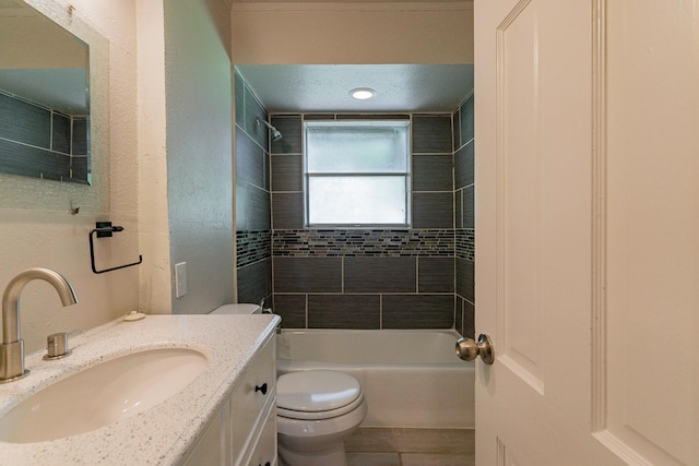 full bathroom with toilet, tiled shower / bath, and vanity