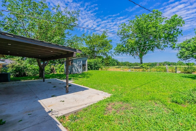 view of yard featuring a storage unit and a patio