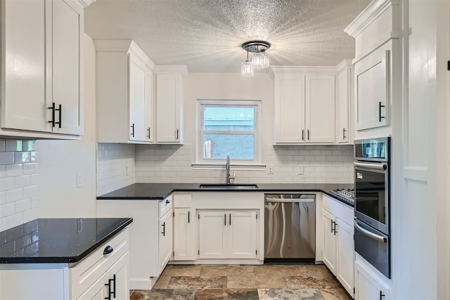 kitchen with sink, decorative light fixtures, white cabinets, stainless steel appliances, and backsplash