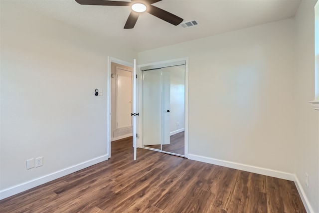 unfurnished bedroom with ceiling fan, dark hardwood / wood-style floors, and a closet