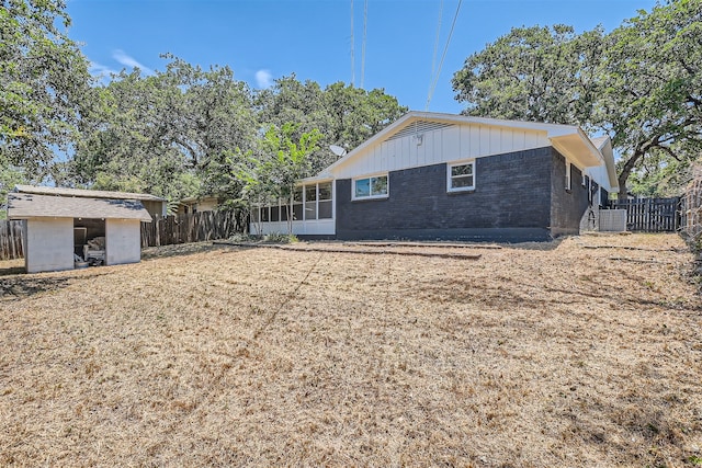 back of property featuring a sunroom and central AC