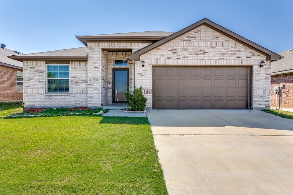 view of front of property featuring a garage and a front lawn