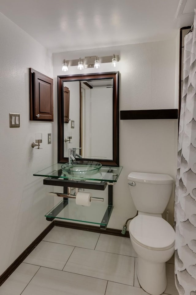 bathroom with tile patterned flooring, sink, and toilet