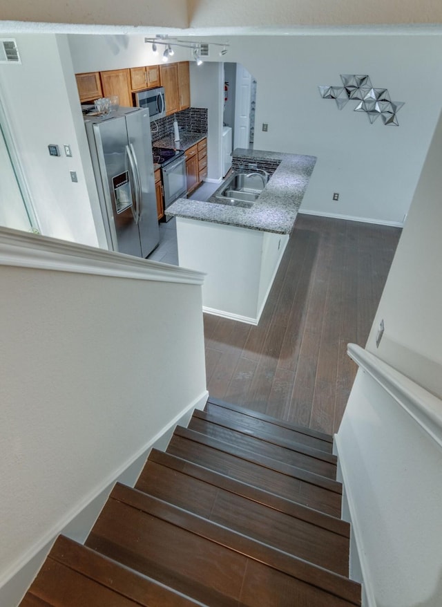 stairway with sink and hardwood / wood-style flooring