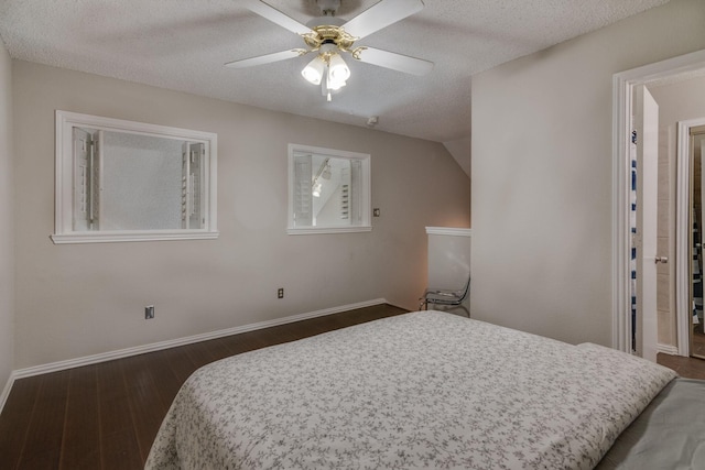 bedroom featuring a textured ceiling, vaulted ceiling, dark hardwood / wood-style floors, and ceiling fan