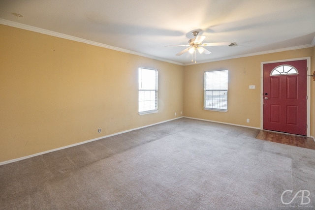 foyer entrance featuring ornamental molding, carpet, and ceiling fan