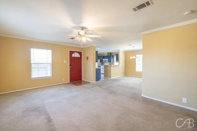 unfurnished living room with ceiling fan with notable chandelier, light colored carpet, a healthy amount of sunlight, and crown molding