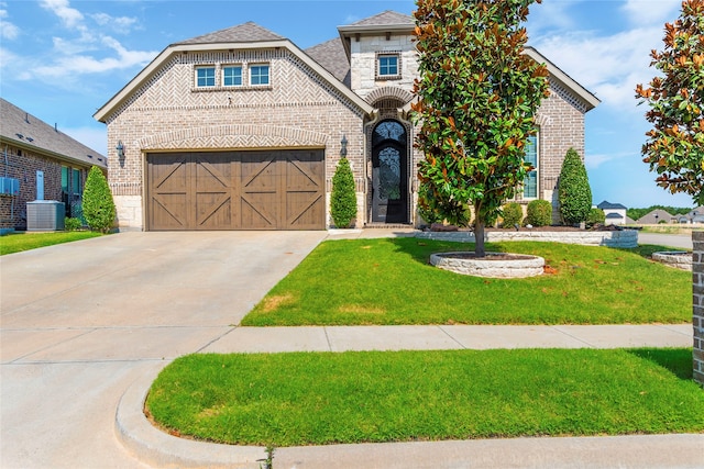 view of front of house with cooling unit, a front yard, and a garage