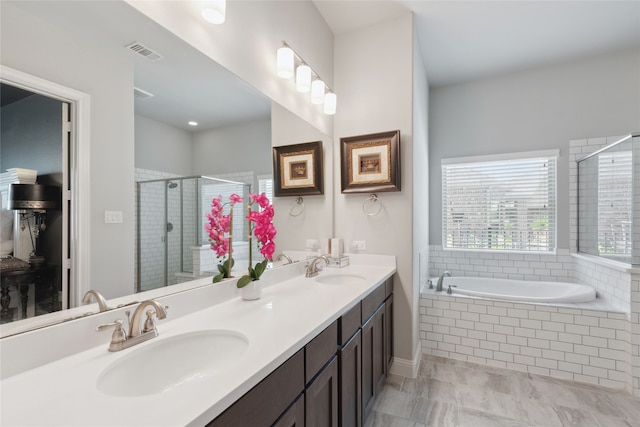 bathroom with vanity and shower with separate bathtub