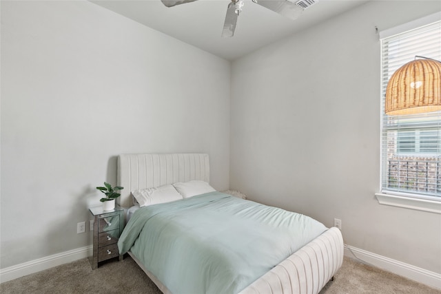 bedroom featuring multiple windows, light colored carpet, and ceiling fan