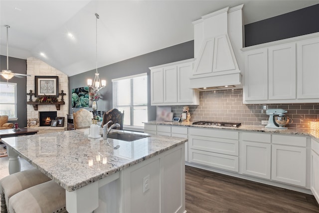 kitchen with white cabinetry, vaulted ceiling, and custom exhaust hood