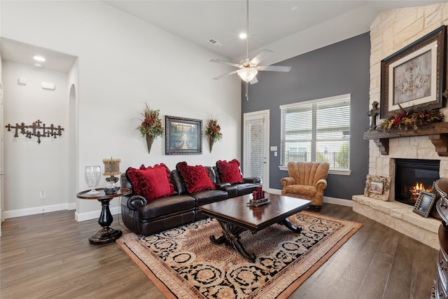 living room featuring a fireplace, hardwood / wood-style floors, high vaulted ceiling, and ceiling fan