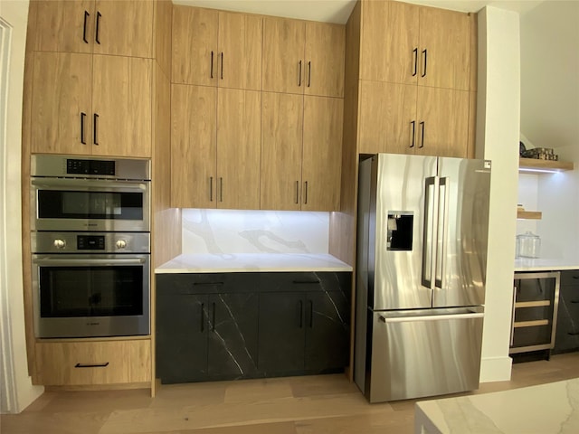 kitchen with wine cooler, light brown cabinets, backsplash, and appliances with stainless steel finishes