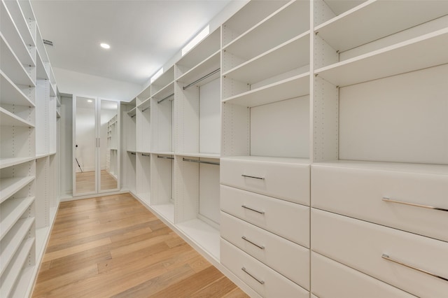 walk in closet with hardwood / wood-style flooring