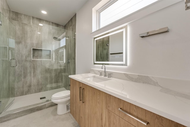 bathroom featuring tile patterned flooring, vanity, toilet, and a shower with door