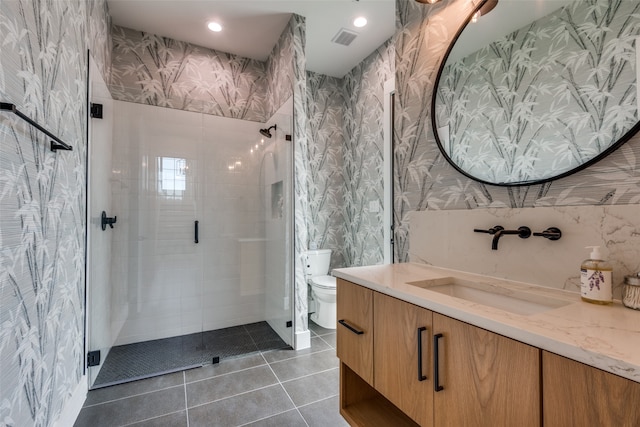 bathroom with tile patterned floors, vanity, toilet, and an enclosed shower