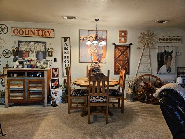 carpeted dining room featuring a barn door and a textured ceiling