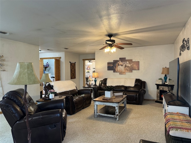 carpeted living room with a fireplace and ceiling fan