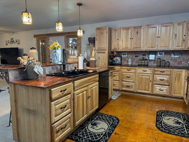 kitchen with pendant lighting, dishwasher, sink, a breakfast bar area, and backsplash