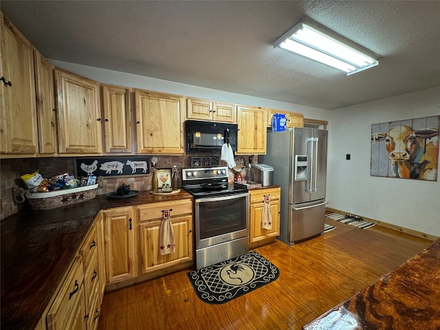 kitchen with stainless steel appliances, dark hardwood / wood-style floors, backsplash, and a textured ceiling