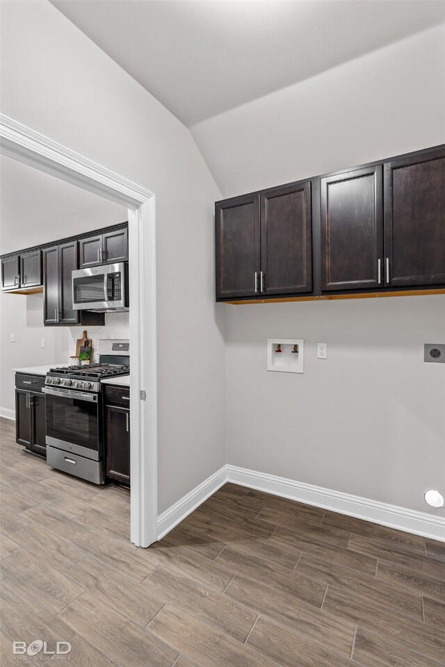 washroom with electric dryer hookup, hardwood / wood-style flooring, and hookup for a washing machine