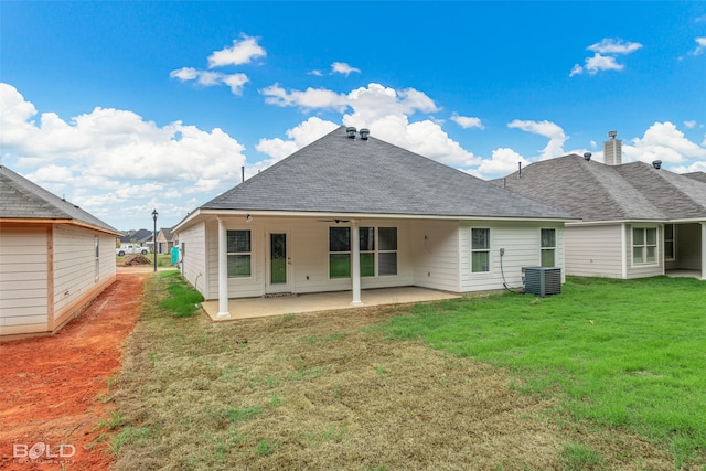 rear view of property with central air condition unit, a patio, and a lawn