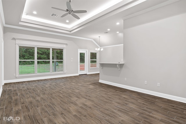 unfurnished living room featuring a tray ceiling, crown molding, dark wood-type flooring, and ceiling fan with notable chandelier