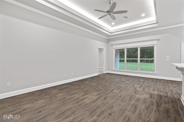 unfurnished living room featuring ceiling fan, dark wood-type flooring, ornamental molding, and a tray ceiling