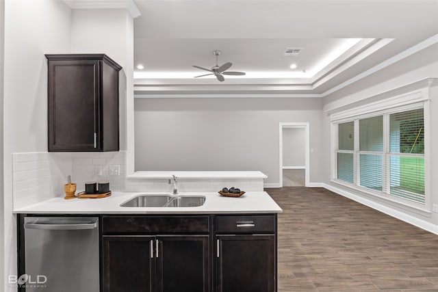 kitchen featuring stainless steel dishwasher, ceiling fan, a tray ceiling, sink, and backsplash