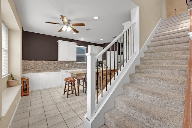 stairway with a ceiling fan, tile patterned floors, visible vents, and recessed lighting