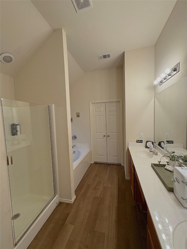 bathroom with a shower stall, wood finished floors, visible vents, and a sink