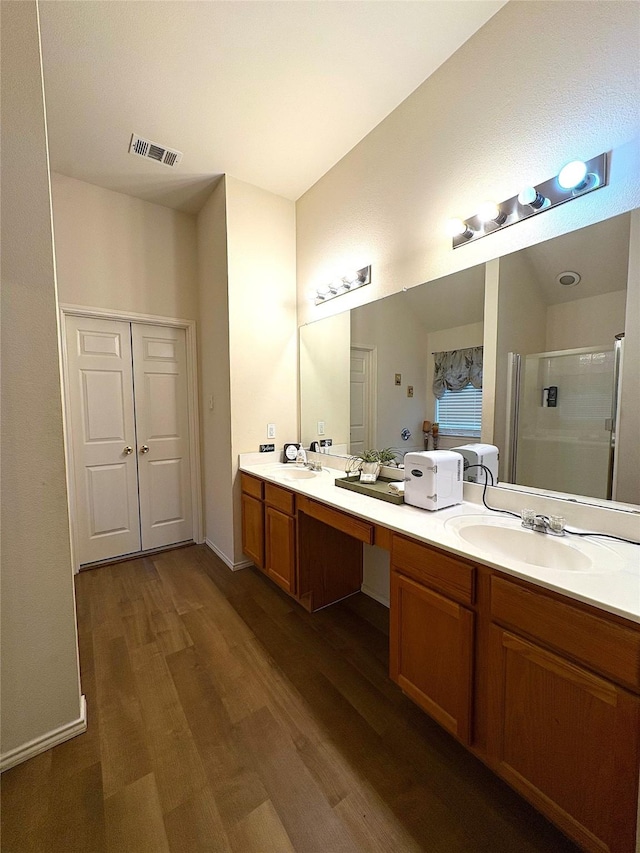 full bath with wood finished floors, visible vents, a sink, and a shower stall
