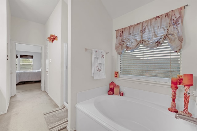 bathroom featuring a washtub and lofted ceiling