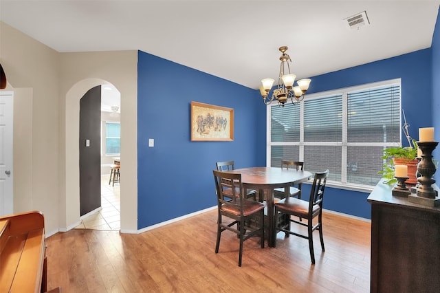 dining area featuring light hardwood / wood-style floors and a notable chandelier