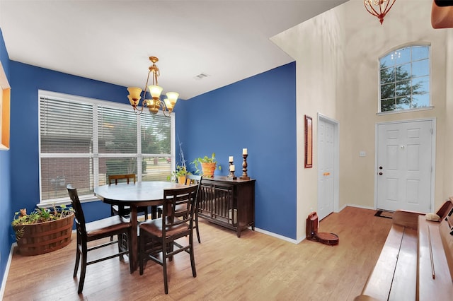 dining space featuring a notable chandelier and light wood-type flooring