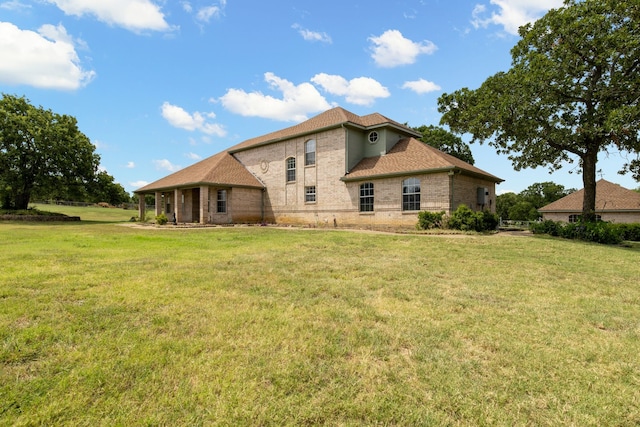 rear view of property featuring a lawn